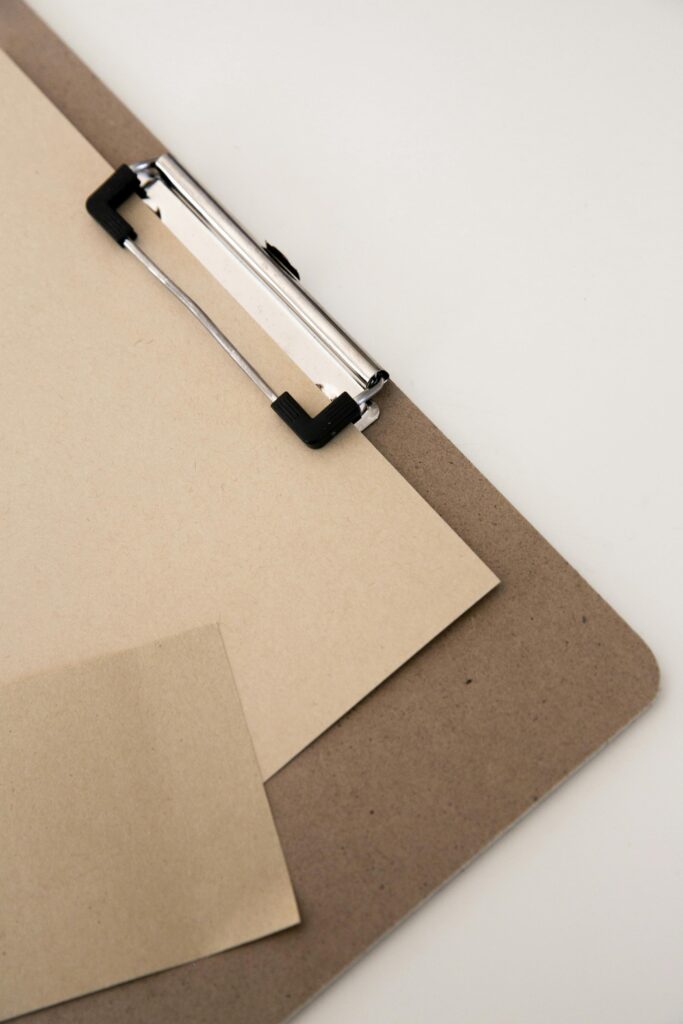 pexels-photo-8250906-8250906 A minimalist setup featuring a clipboard with brown paper sheets, ideal for stationery themes.